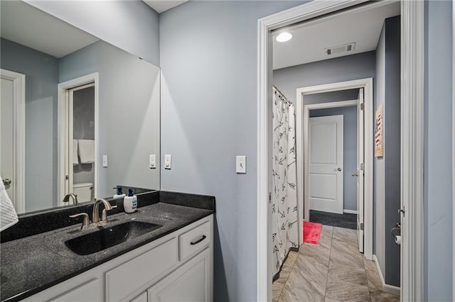full bathroom featuring vanity, baseboards, and visible vents