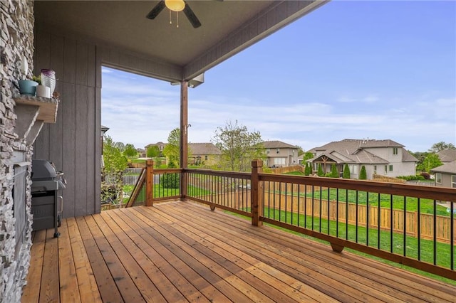 wooden deck with area for grilling, a ceiling fan, a residential view, and a fenced backyard