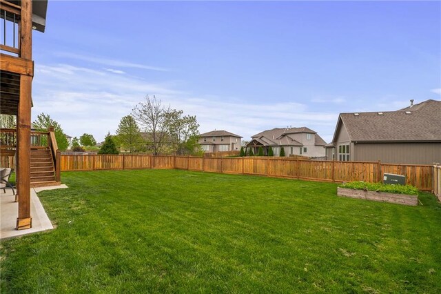 view of yard featuring a fenced backyard, stairs, a patio area, and a residential view