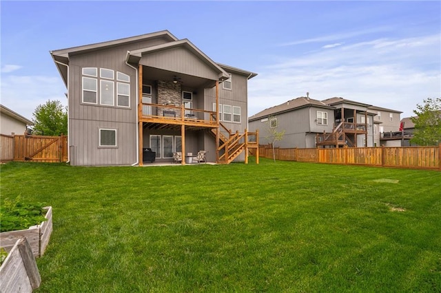 rear view of property featuring a fenced backyard, a yard, and stairway