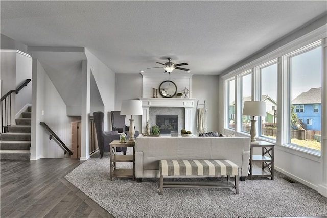 living room featuring stairway, a ceiling fan, wood finished floors, baseboards, and visible vents