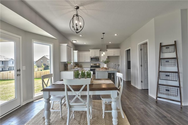 dining space with a chandelier, baseboards, dark wood-style flooring, and recessed lighting