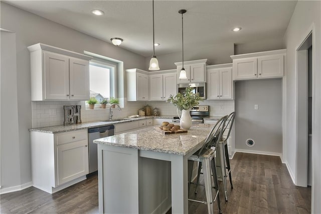 kitchen with white cabinets, backsplash, and appliances with stainless steel finishes