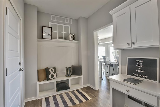 mudroom featuring baseboards, visible vents, and dark wood-style floors