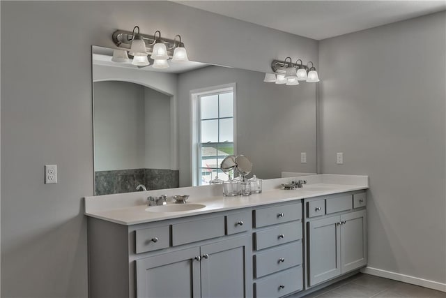 full bathroom with double vanity, tile patterned floors, and a sink