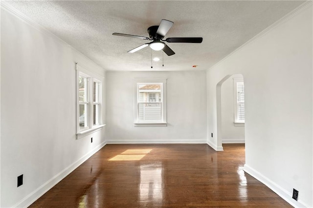 unfurnished room featuring arched walkways, a textured ceiling, ceiling fan, and wood finished floors