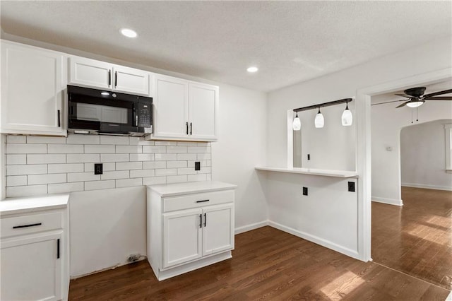 kitchen with decorative backsplash, ceiling fan, black microwave, dark wood finished floors, and white cabinetry