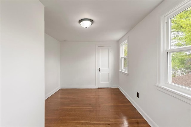 empty room with baseboards and wood finished floors