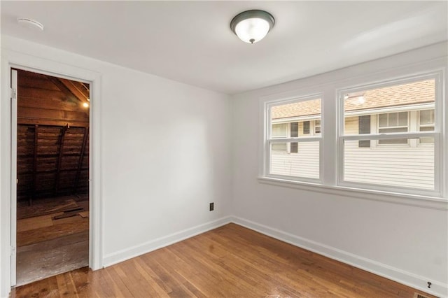 unfurnished room with baseboards and light wood-type flooring