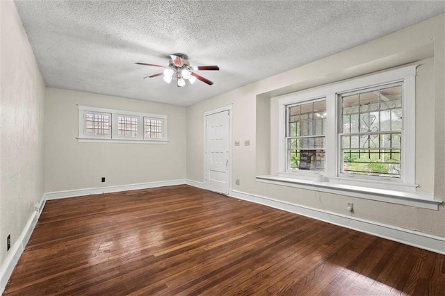spare room featuring wood-type flooring, a textured ceiling, ceiling fan, and baseboards