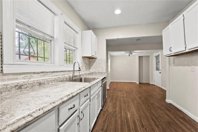 kitchen featuring white cabinetry, baseboards, dark wood finished floors, and a sink