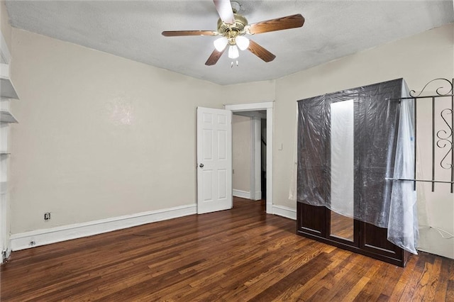 unfurnished bedroom with a textured ceiling, baseboards, a ceiling fan, and wood finished floors