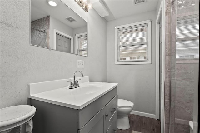 bathroom featuring visible vents, wood finished floors, a healthy amount of sunlight, and toilet