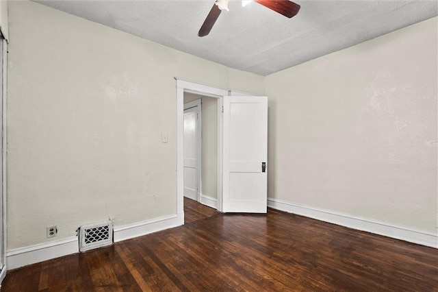 spare room with baseboards, ceiling fan, wood finished floors, and visible vents