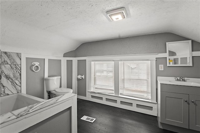 full bathroom featuring wood finished floors, visible vents, a textured ceiling, and lofted ceiling