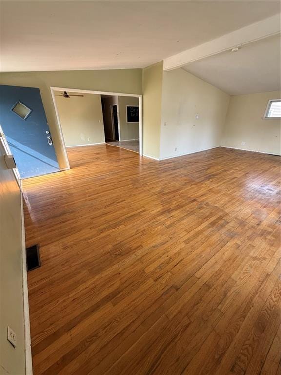 unfurnished room with baseboards, wood finished floors, and lofted ceiling