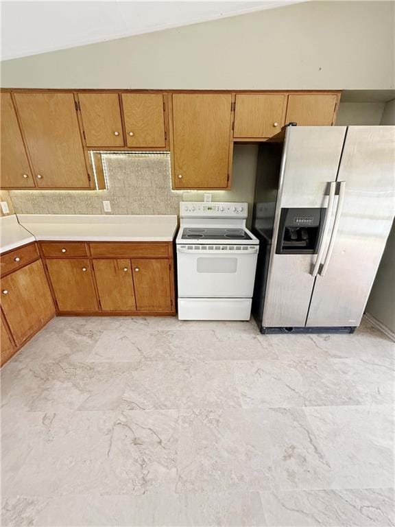 kitchen featuring light countertops, stainless steel fridge with ice dispenser, vaulted ceiling, and electric range