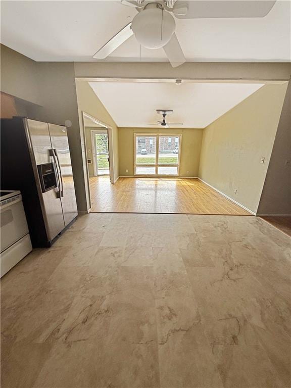 unfurnished living room featuring baseboards, ceiling fan, and vaulted ceiling