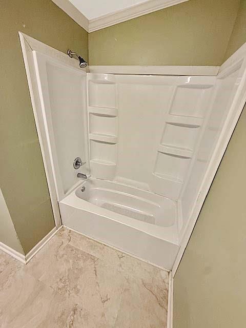 full bathroom with crown molding, shower / tub combination, and marble finish floor