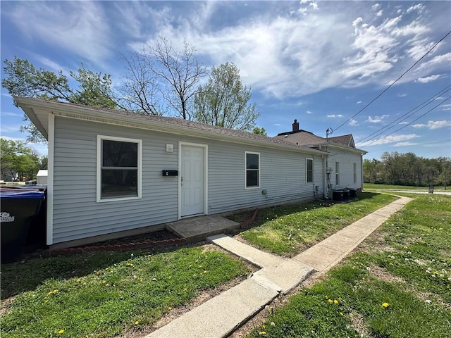 view of front of house with central air condition unit and a front yard