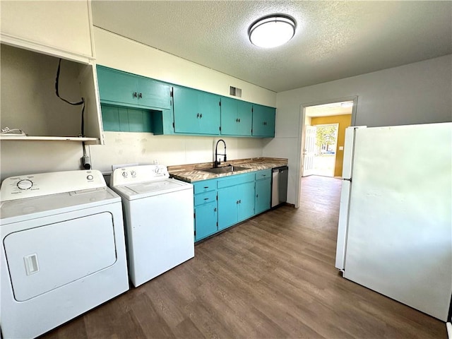 clothes washing area featuring washer and dryer, dark wood-type flooring, a sink, and a textured ceiling