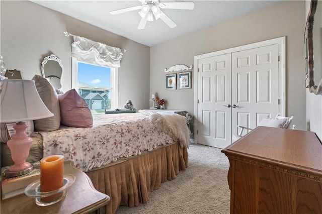 bedroom with ceiling fan, a closet, and light colored carpet