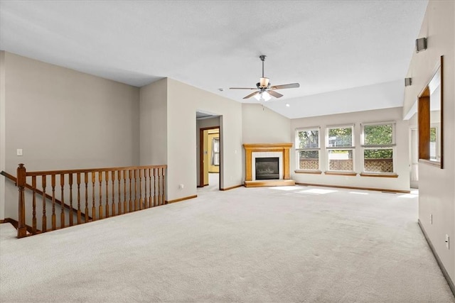 22716 E 29th Street Lane Ct S, Blue Springs, MO 64015 - unfurnished living room with carpet floors, ceiling fan, baseboards, a tiled fireplace, and lofted ceiling