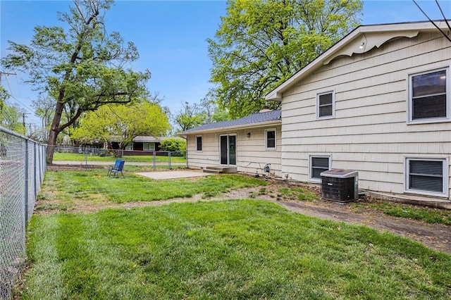 back of property with a lawn, a fenced backyard, a patio area, and central AC