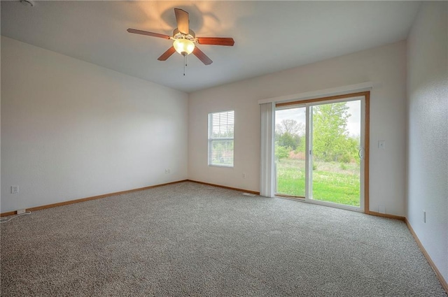 empty room featuring a ceiling fan, baseboards, and carpet