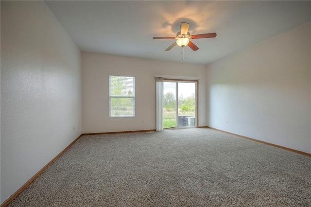 spare room with baseboards, ceiling fan, and carpet flooring