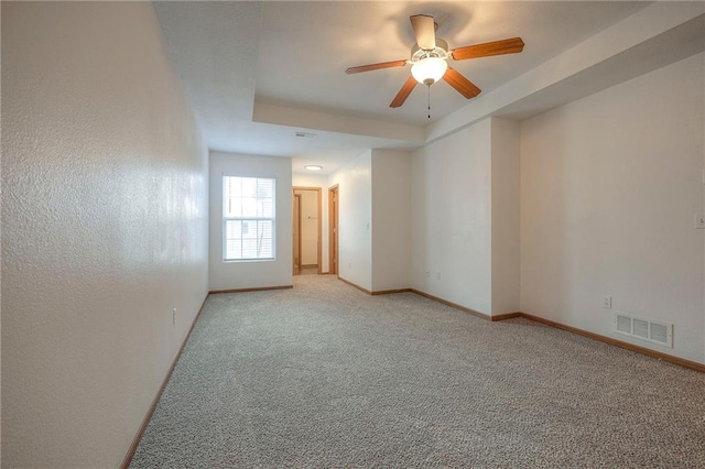 empty room featuring baseboards, ceiling fan, light carpet, and visible vents