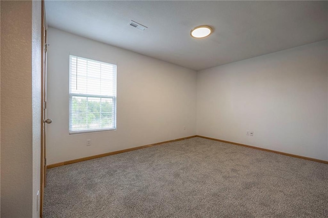 spare room featuring baseboards, carpet, and visible vents