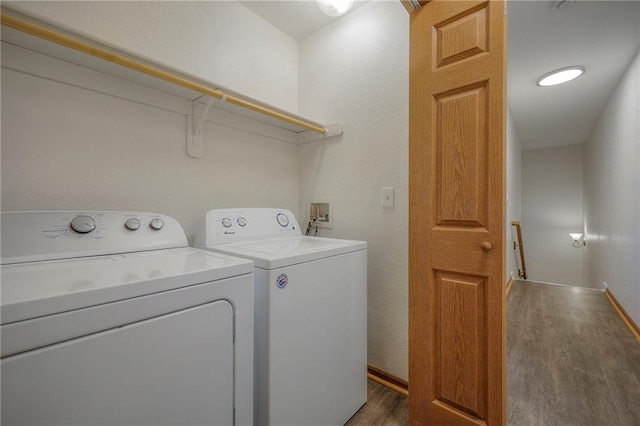 laundry room with laundry area, baseboards, independent washer and dryer, and wood finished floors