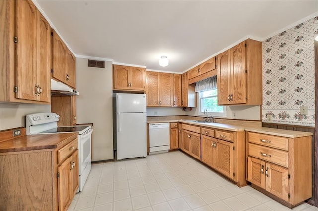 kitchen with crown molding, white appliances, wallpapered walls, under cabinet range hood, and visible vents