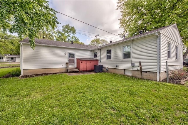 rear view of property with a lawn, a jacuzzi, fence, and entry steps