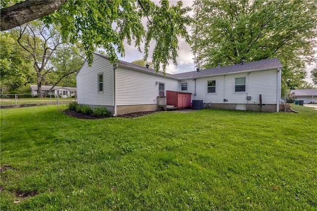 rear view of property featuring a yard and cooling unit