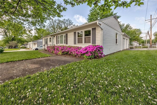 view of side of property with a lawn and a garage