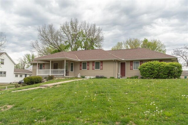 single story home featuring a porch and a front lawn
