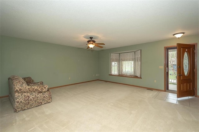 unfurnished room with a ceiling fan, a textured ceiling, light carpet, baseboards, and visible vents