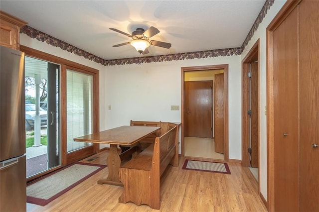 dining space featuring light wood-type flooring, a wealth of natural light, and a ceiling fan