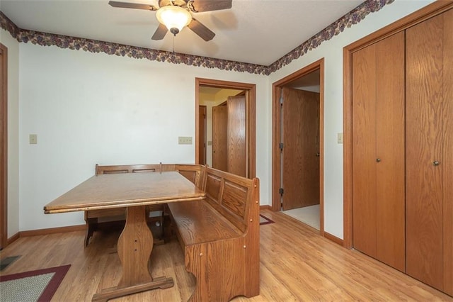 unfurnished dining area featuring light wood-style flooring, baseboards, and a ceiling fan