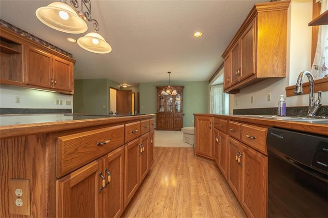 kitchen with light wood finished floors, brown cabinetry, dishwasher, and a sink
