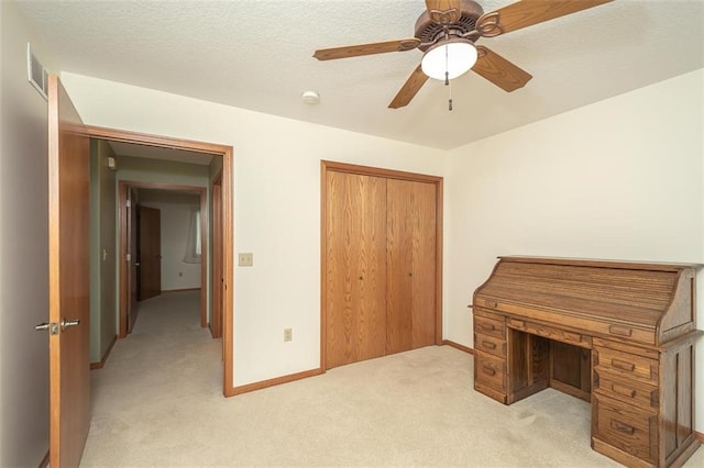 unfurnished office with ceiling fan, light carpet, visible vents, and baseboards