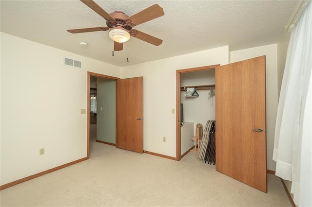unfurnished bedroom with baseboards, visible vents, a textured ceiling, and light colored carpet
