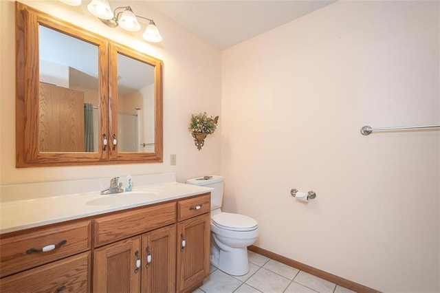 bathroom with baseboards, vanity, tile patterned flooring, and toilet