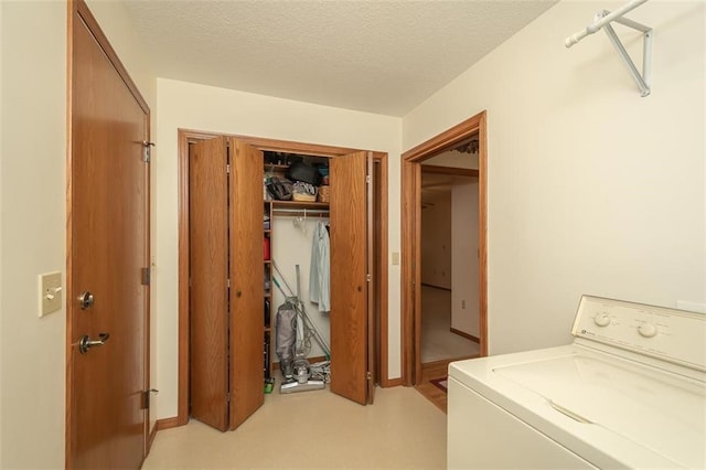 clothes washing area with a textured ceiling, laundry area, and washer / clothes dryer
