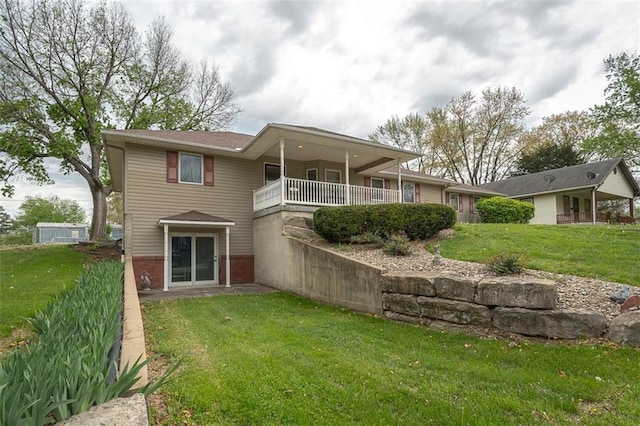 back of property with a lawn, brick siding, and a balcony