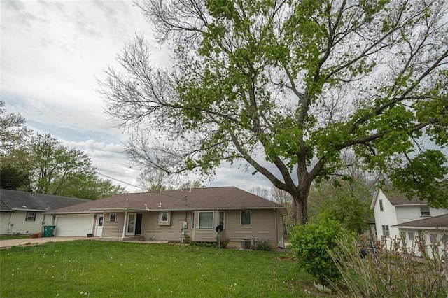 view of front of property featuring driveway, a front yard, and a garage