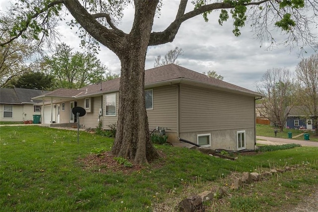 view of side of home with a lawn and an attached garage