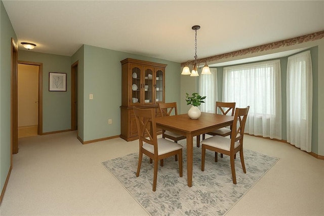 915 Walnut St, Valley Falls, KS 66088 - dining room featuring light carpet, baseboards, and a chandelier